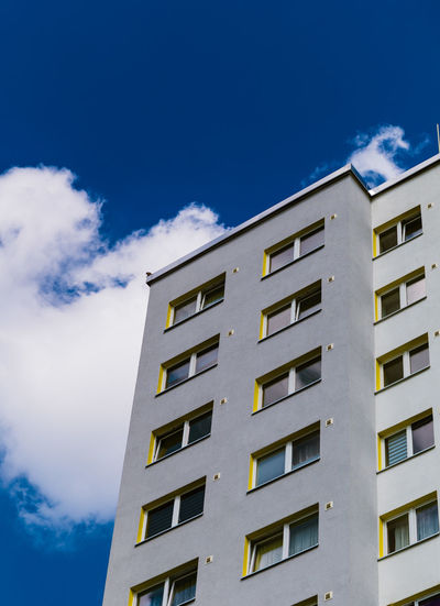Low angle view of apartment building against blue sky