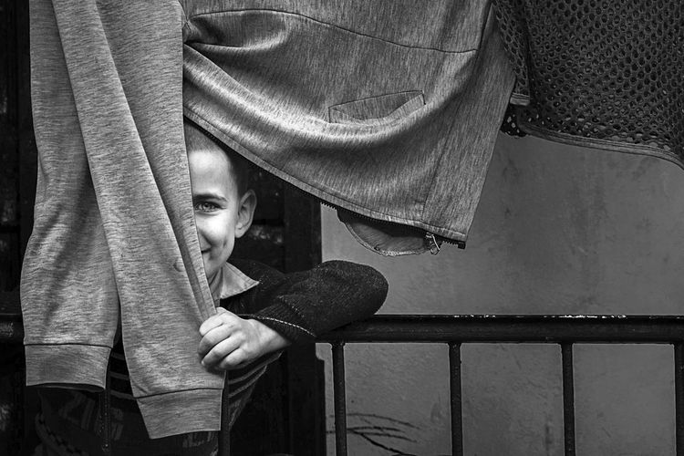 Portrait of boy hiding behind cloth