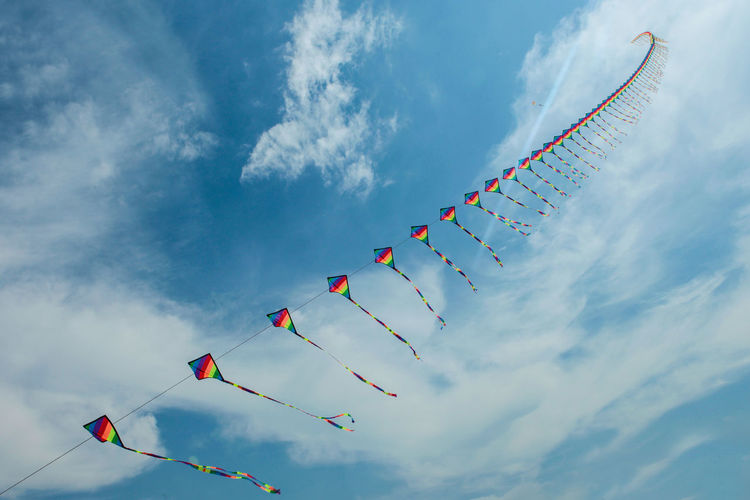 Low angle view of multi colored kites against sky