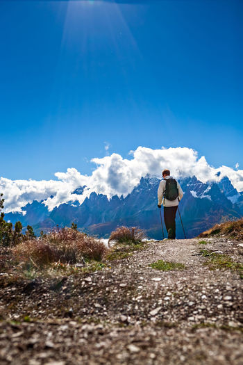Woman standing on mountain against blue sky