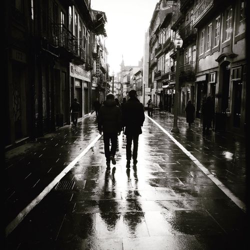 Rear view of people walking on wet street in rain