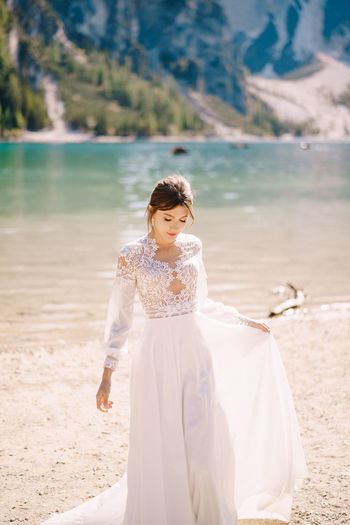 Beautiful bride standing by lakeshore