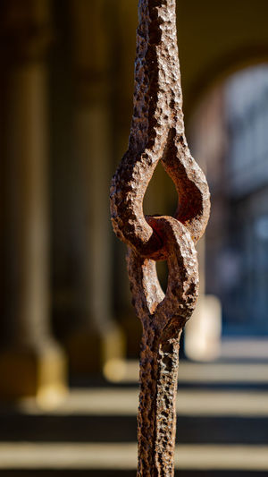 Close-up of rusty chain hanging on railing