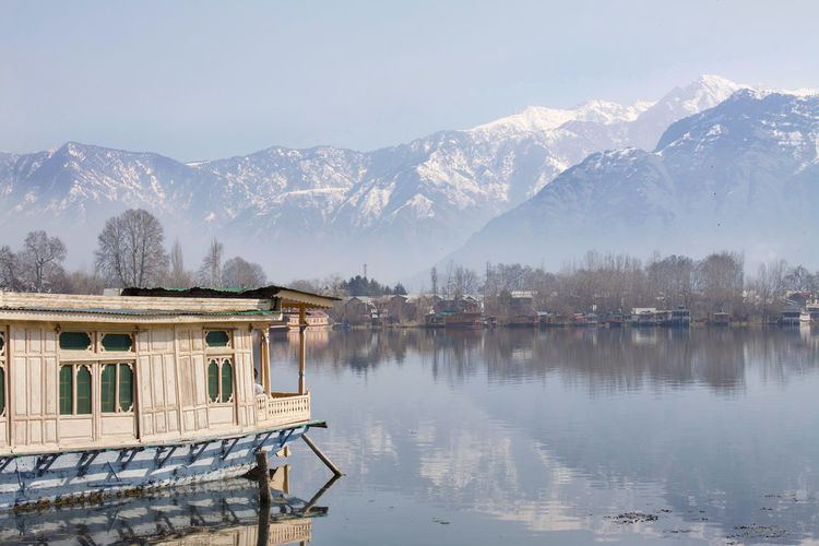 Scenic view of lake by snowcapped mountains against clear sky