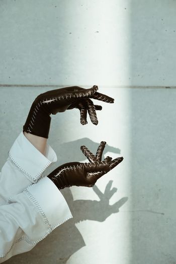 Close-up of woman hand on wall leather gloves