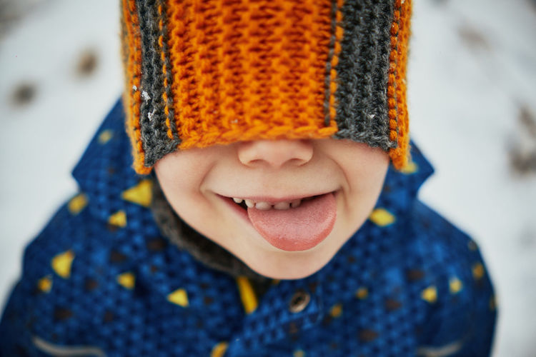 Boy showing tongue during winter