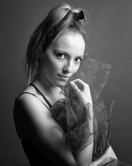 Close-up of young woman standing against wall