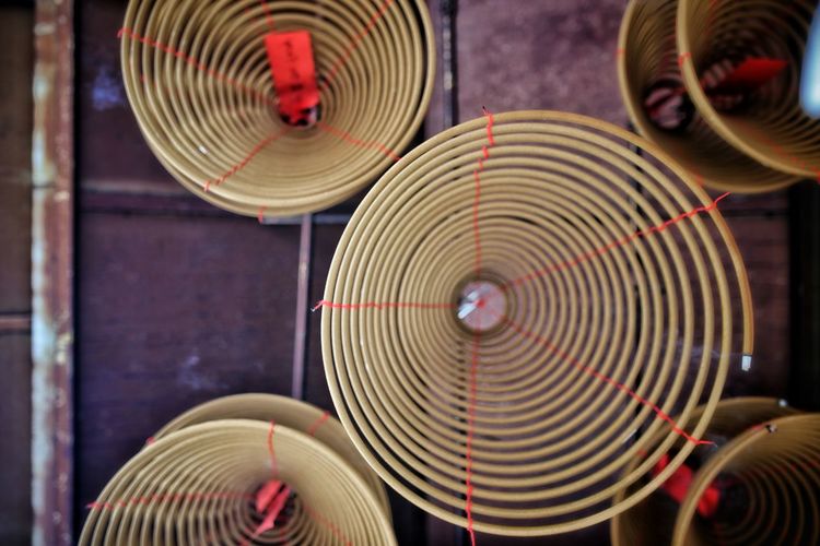 Low angle view of incense coils hanging from ceiling in temple