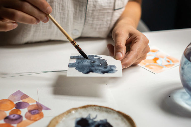 Female painter artist draw an abstract watercolor painting.