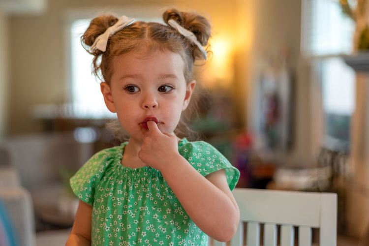 Cute girl eating chocolate at home