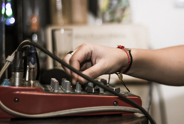 Cropped hand adjusting sound mixer knob