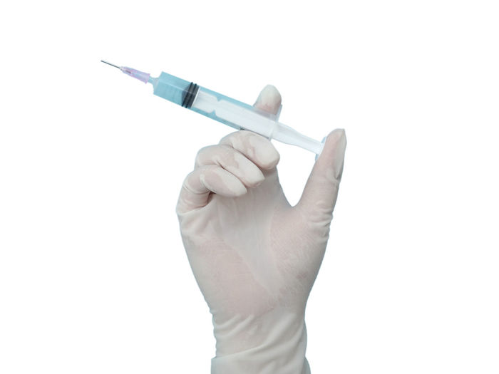 Close-up of hand holding pen against white background