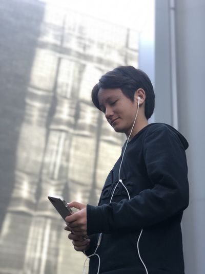Teenage girl listening to music while using phone