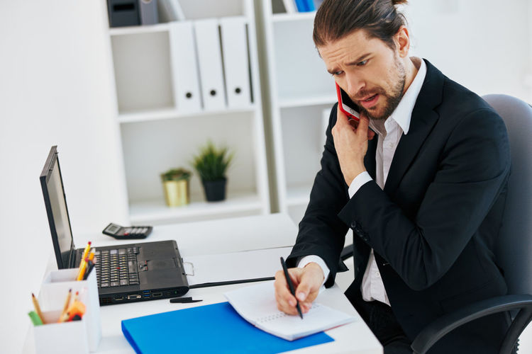 Businessman talking on phone while working in office