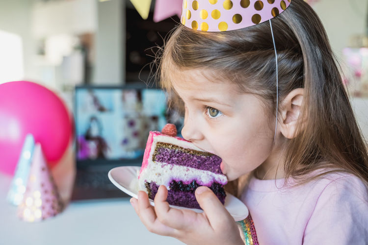 Cute girl eating cake in plate