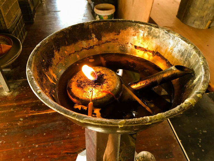 High angle view of tea light candle burning in temple