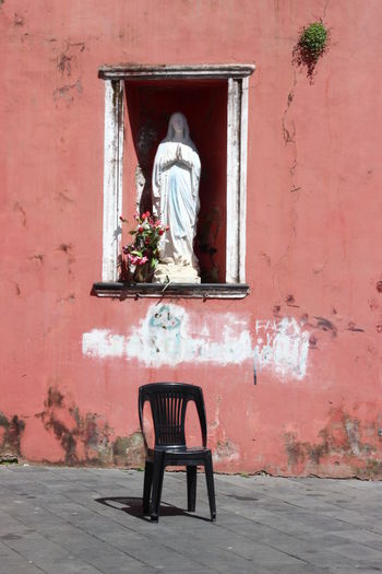 Virgin mary sculpture on niche by footpath