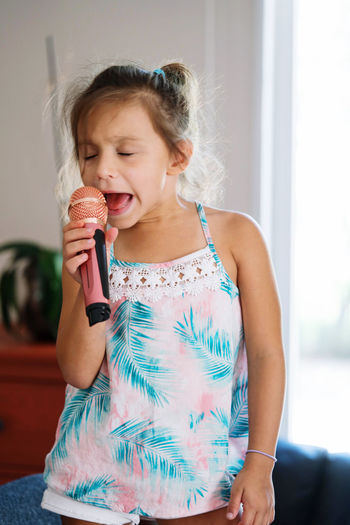 Girl singing with a microphone at home
