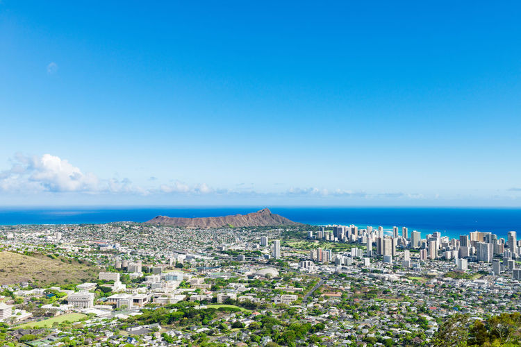 High angle view of cityscape by sea against clear sky