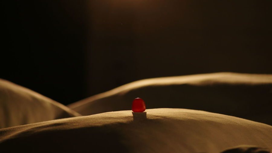 Close-up of red light bulb on bed