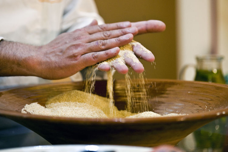 Close-up of hands scattering wheat