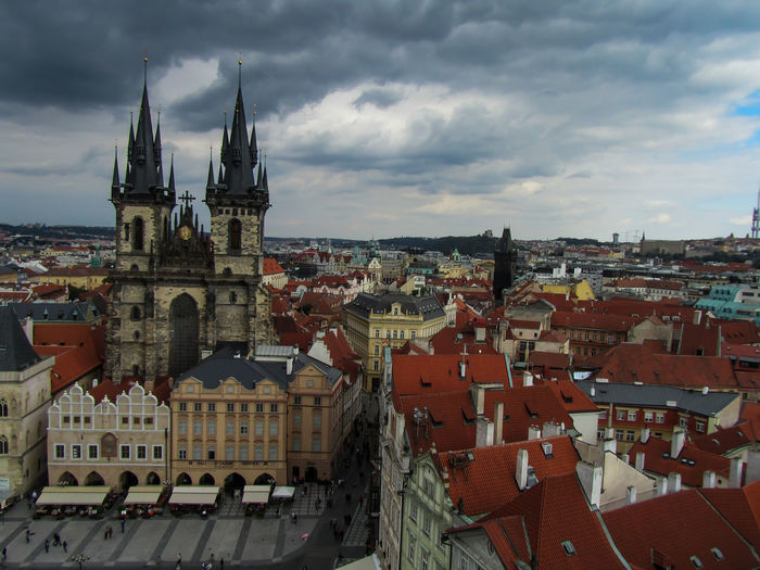 High angle view of tyn church and cityscape against cloudy sky