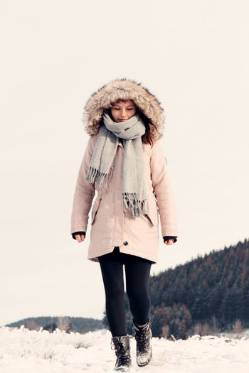 Full length portrait of woman standing in snow