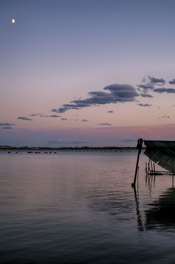 Pier over sea against sky at sunset