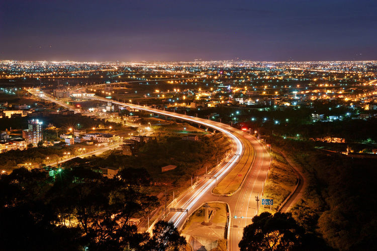 Aerial view of light trails on road in city at night