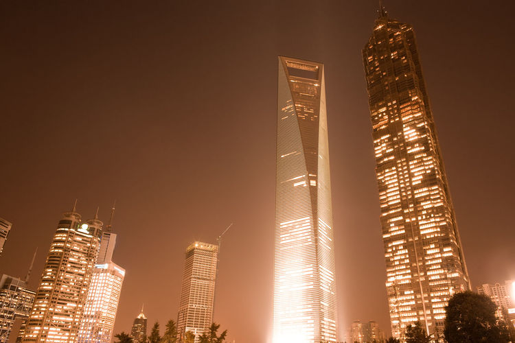 Low angle view of illuminated skyscrapers against sky at night