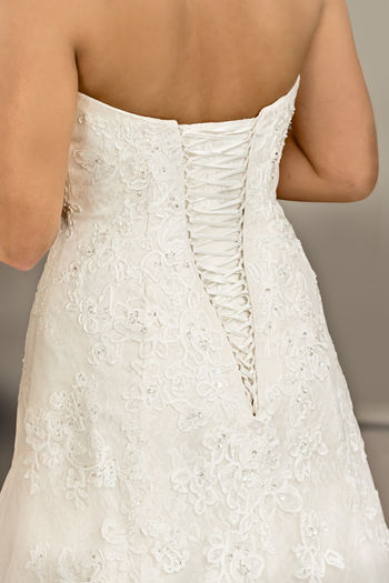 Midsection of woman standing against white wall