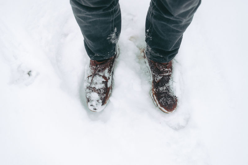 Low section of person standing on snow