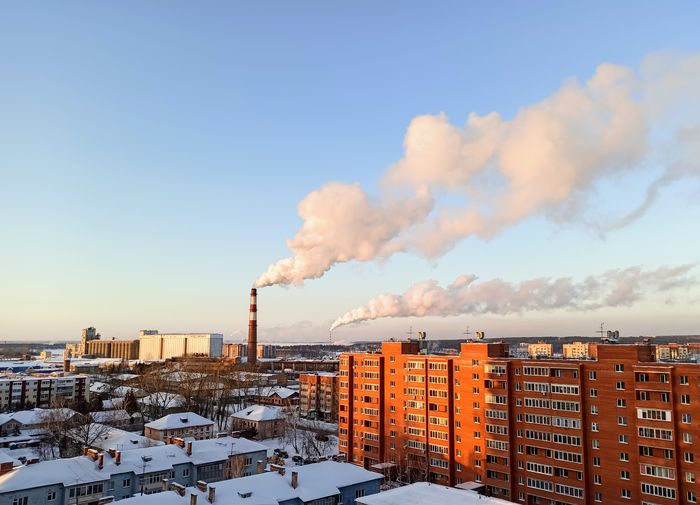 Smoke emitting from chimney against sky during winter
