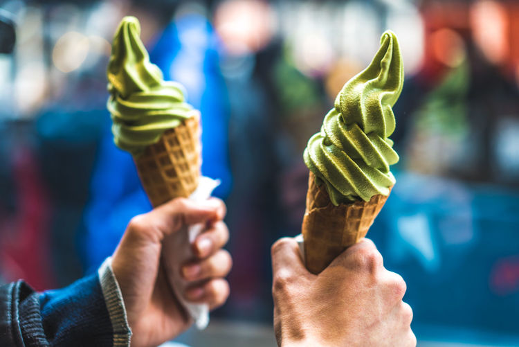 Cropped hands of people holding ice creams outdoors