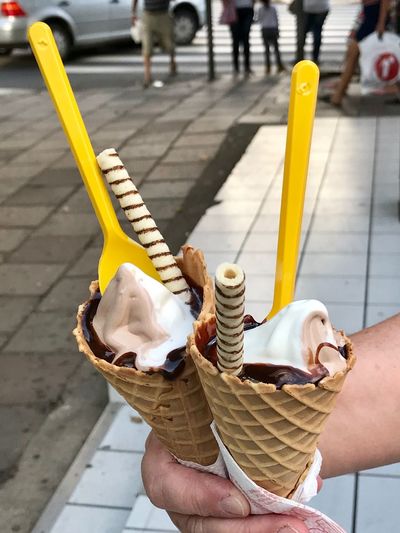 People holding ice cream on footpath