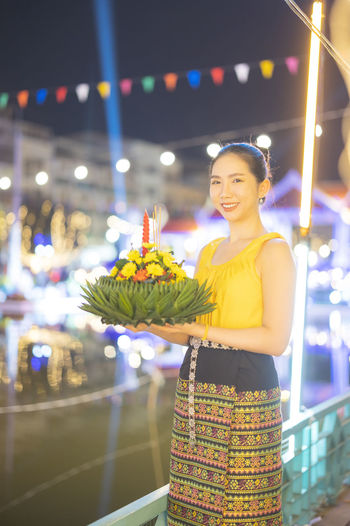Portrait of smiling young woman standing at night
