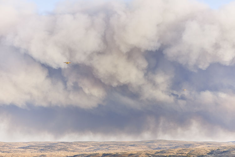 Hydroplane amidst ash clouds working to extinguish a forest fire. natural disaster concept