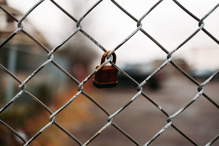 Rusty lock on chain link fence.