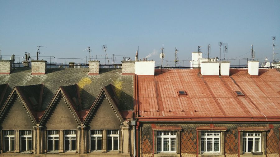 Antennas on roofs of residential buildings against clear sky