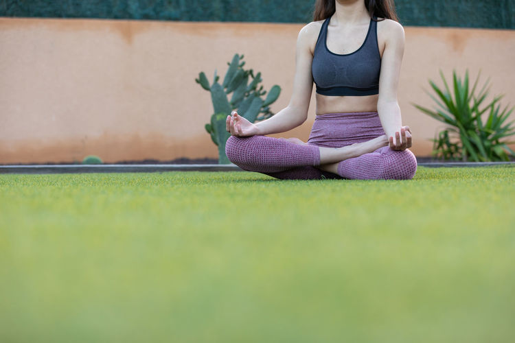 Side view of woman sitting on grass