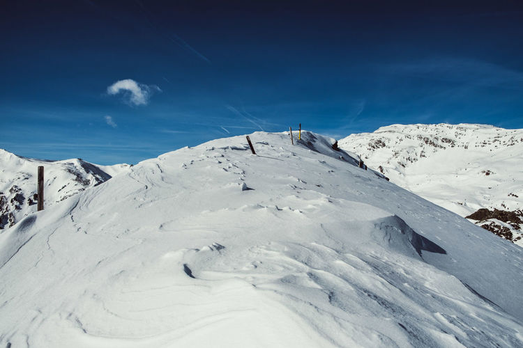 Scenic view of snowcapped mountains against blue sky
