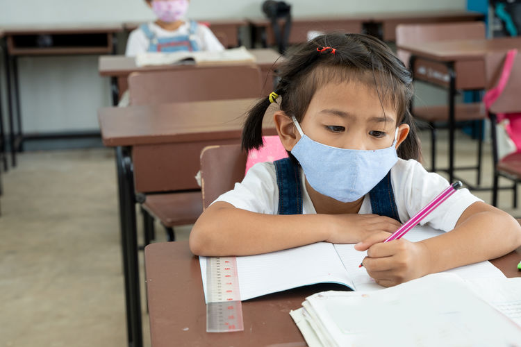 Elementary student with face mask back at school after covid-19