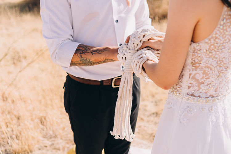 Midsection of couple during wedding ceremony 
