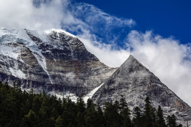 Low angle view of snowcapped mountains against sky