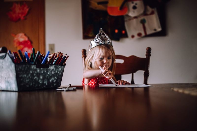 Girl painting on paper at table