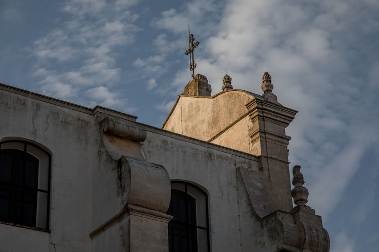 Low angle view of statues on building against sky