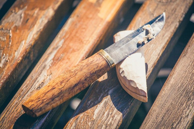 High angle view of knife with wood on table