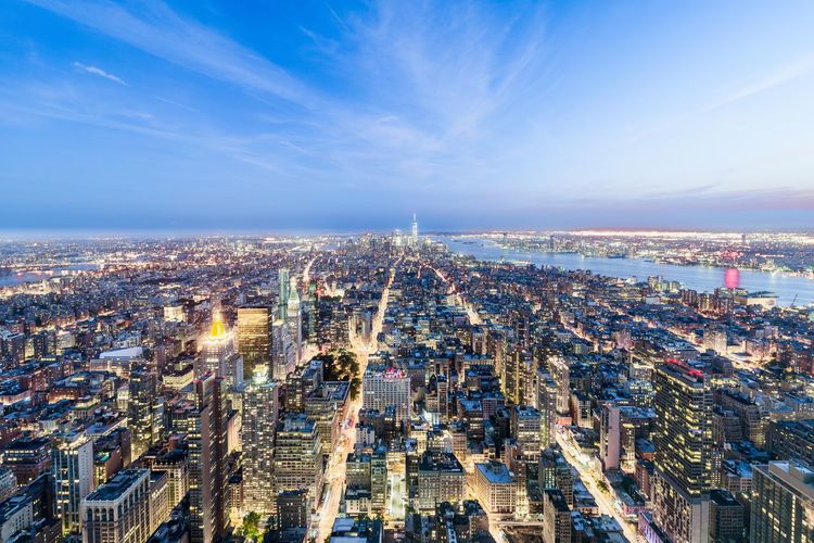 High angle view of city lit up against sky