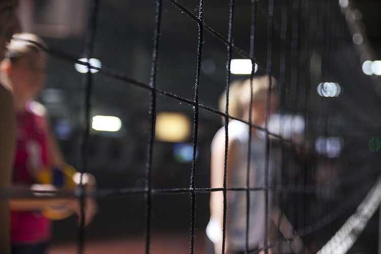 Close-up of people behind volleyball net
