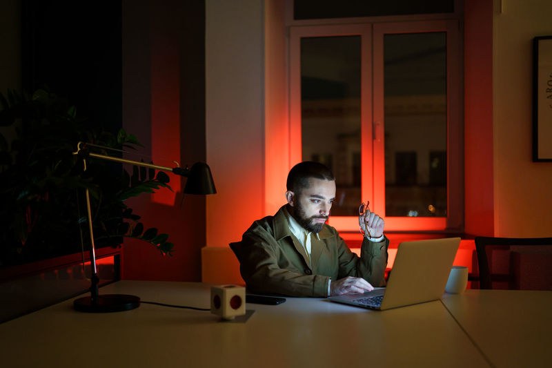 Designer or developer work on website overtime, programmer workaholic stay in office late at night
